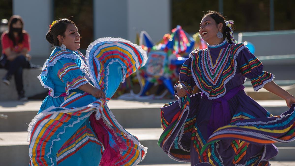 Students at the fiesta at sunset in traditional dress dancing